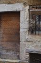 Weathered stone building with shabby doors and latticed window