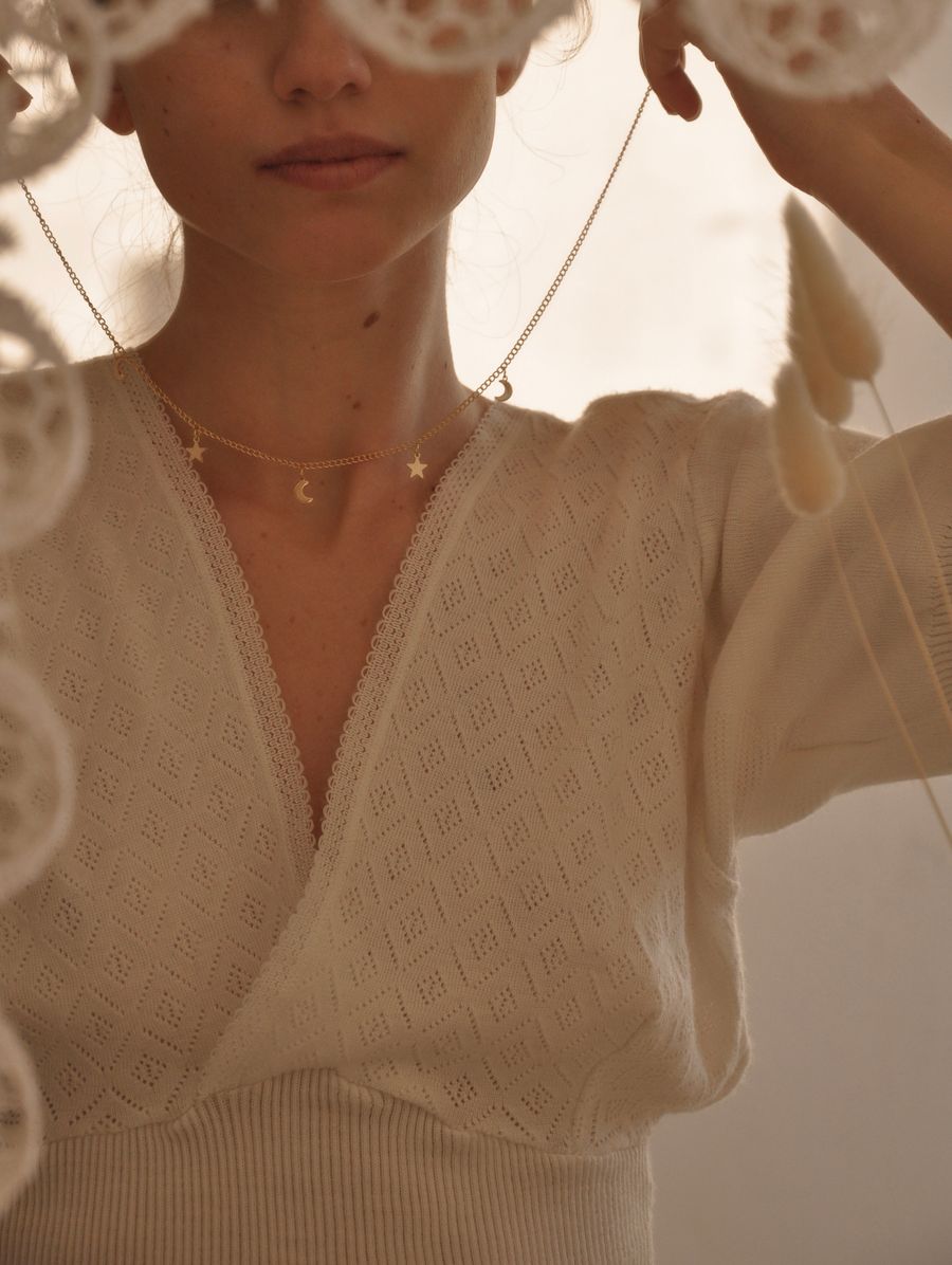 Mujer poniéndose un collar delicado