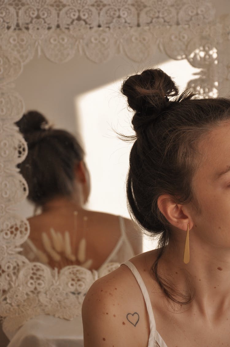 Young Woman With Heart Shaped Tattoo On Shoulder