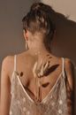 Back view of unrecognizable female in lace top with branches of dry Lagurus plant