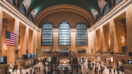 Free Interior view of Grand Central Terminal with an American flag and busy crowd, New York City. Stock Photo