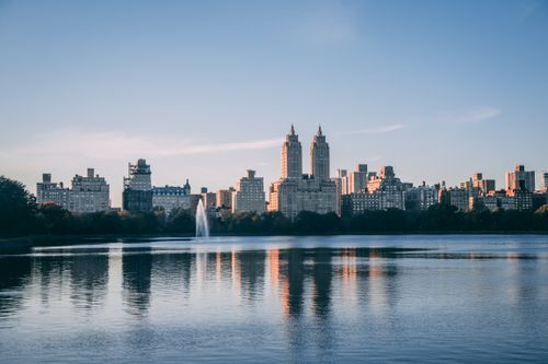 Free A stunning view of New York City's skyline with Central Park Reservoir reflecting the skyscrapers at dusk. Stock Photo
