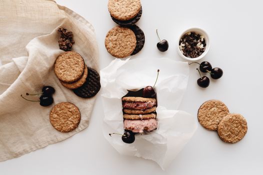 A top-down view of oat cookies, cherries, and chocolate, perfect for gourmet food photography lovers.