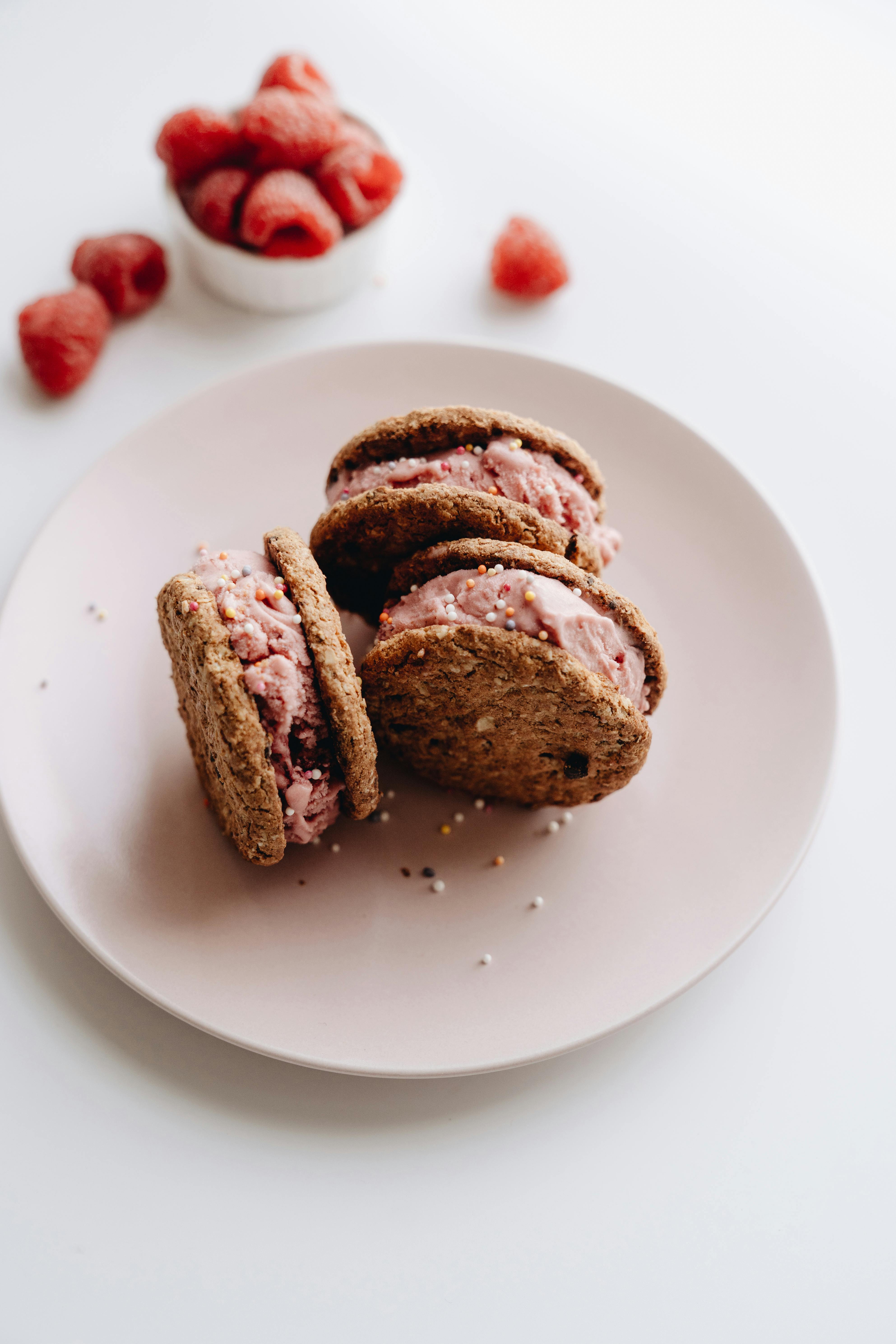 Close-up of raspberry ice cream cookie sandwiches on a plate, perfect for a sweet indulgence.