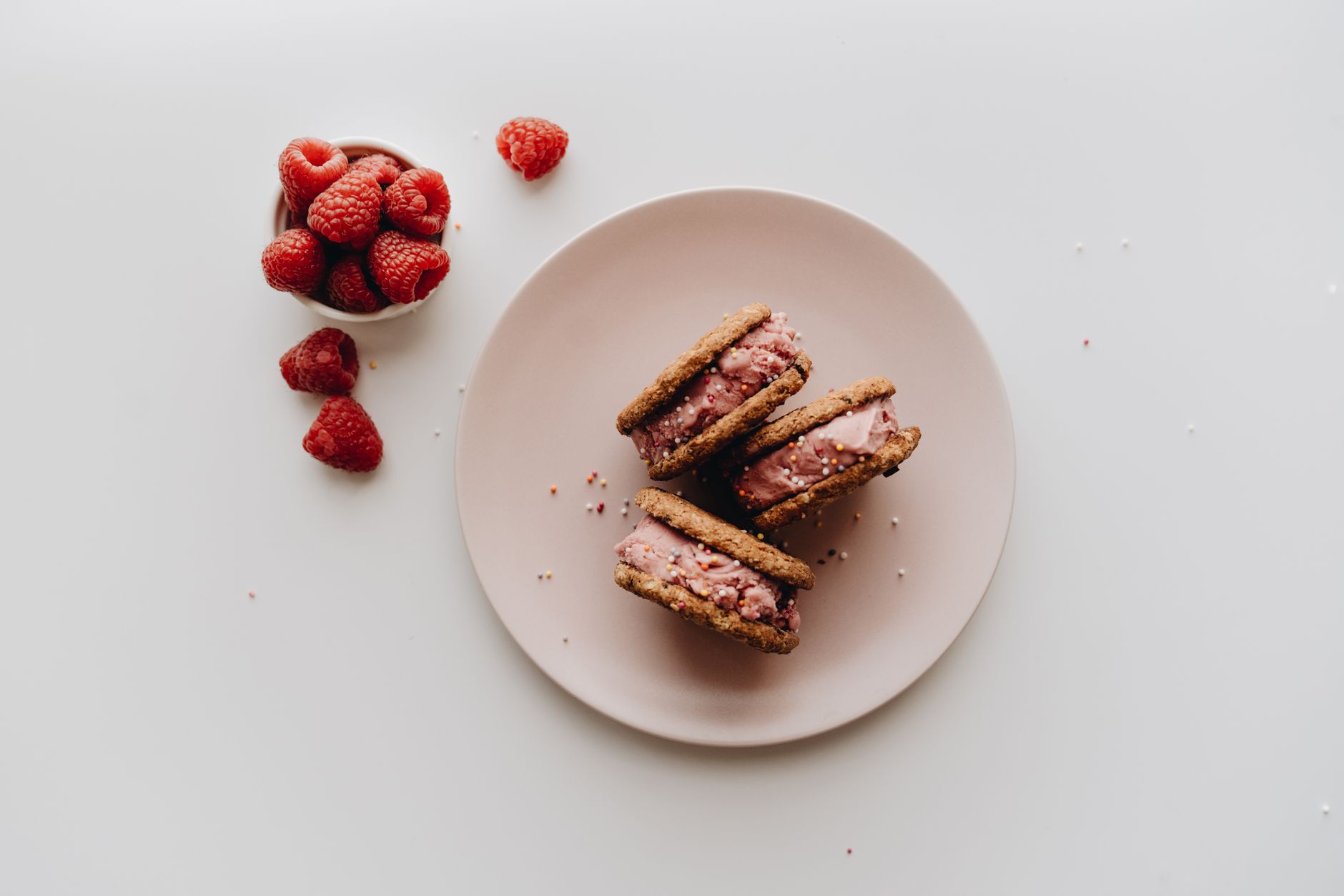 Stacked ice cream sandwiches on a plate with chocolate drizzle and sprinkles
