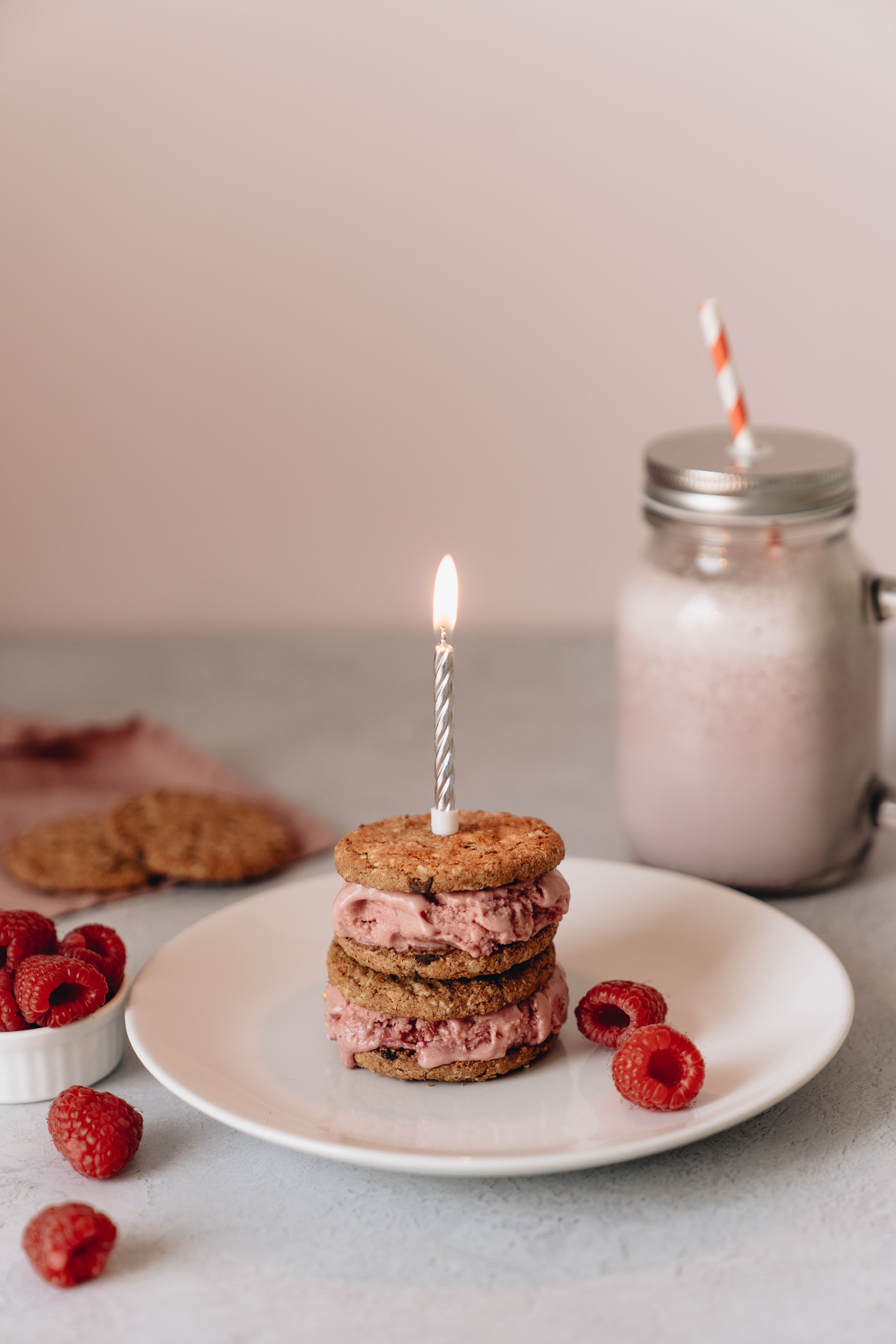 Tasty layered cookie dessert with raspberries and milkshake, perfect for celebrations.