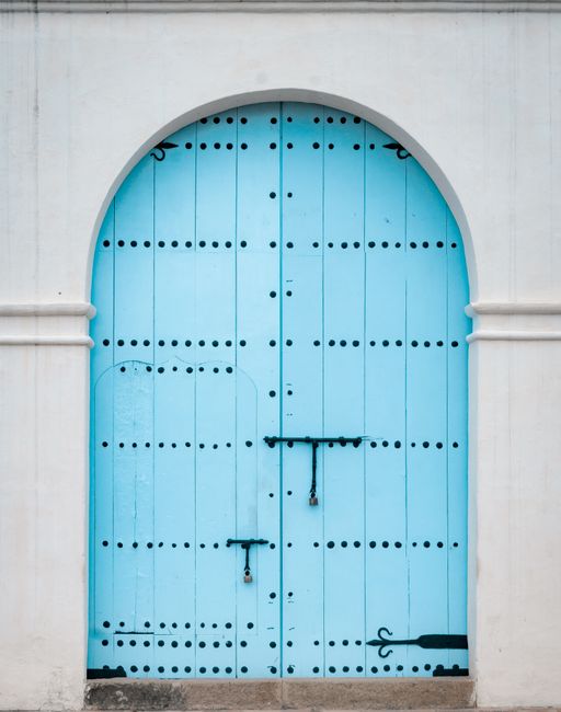 A vibrant blue arched door with traditional Moroccan design elements, offering cultural charm.