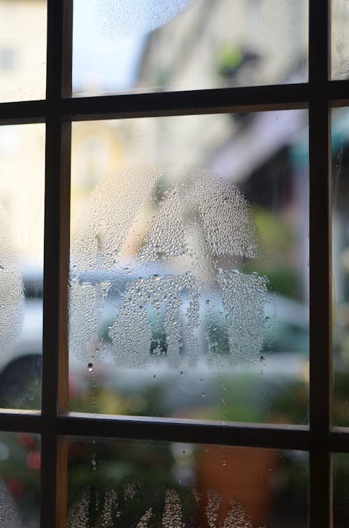 Square shaped frame and misted glass with small water drips in building in daylight