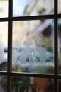 Square shaped frame and misted glass with small water drips in building in daylight