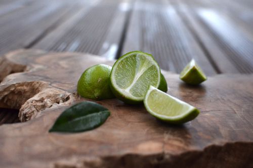 Free Close-up of fresh sliced limes on a wooden surface, showcasing vibrant green and texture. Stock Photo