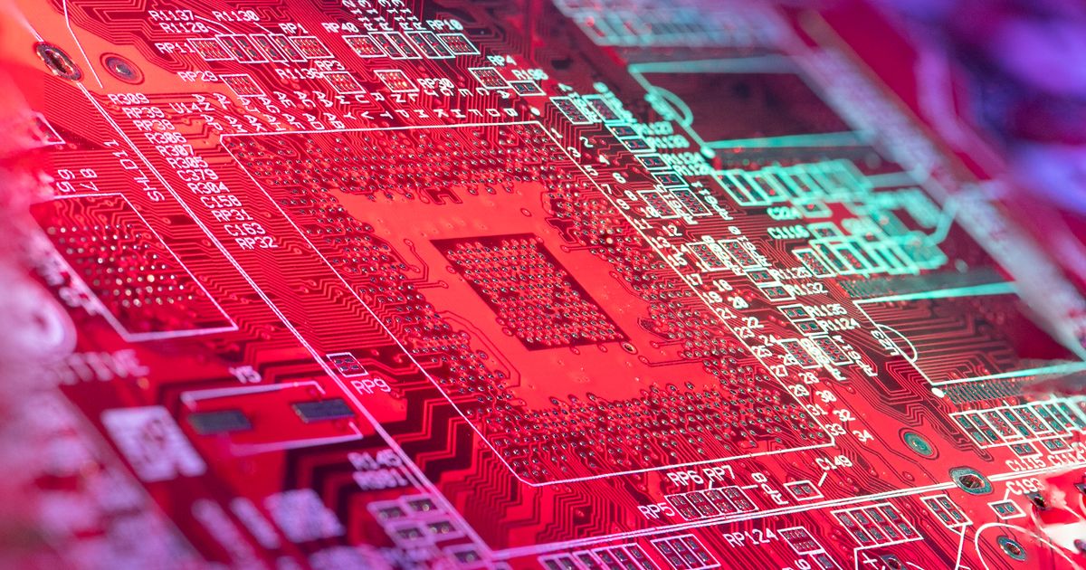 A circuit board with microchip patterns lit in red.