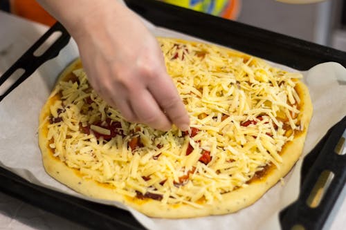Topping of Cheese on a Pizza