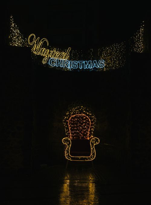 Free Festive illuminated chair with 'Magical Christmas' lights, perfect holiday decoration. Stock Photo