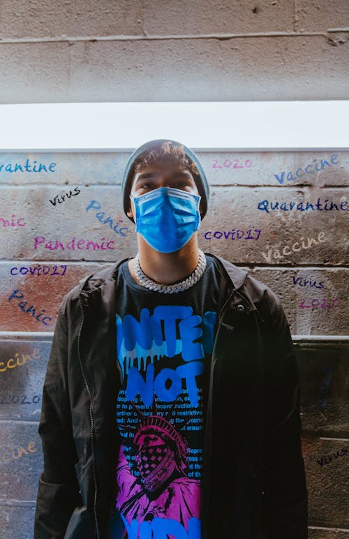 Man in Black Jacket wearing Blue Facemask 