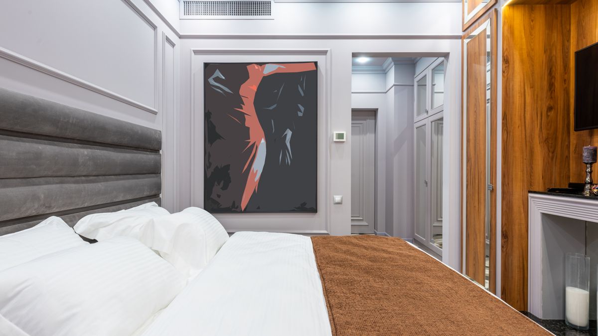 A made-up hotel room with a double bed and soft lighting