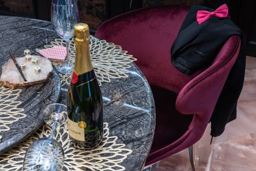 Bottle of champagne between glasses on table
