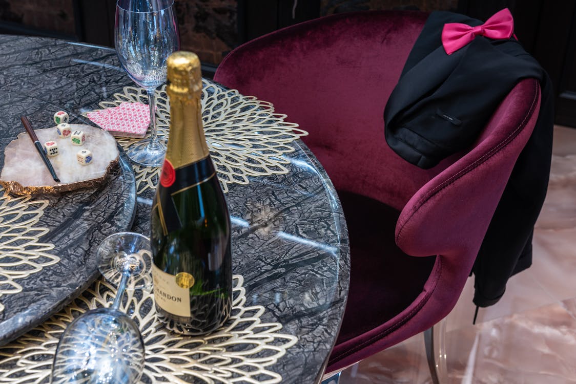 Bottle of champagne between glasses on table