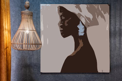 Artwork of African woman on wall against decorative lamp