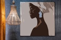 Artwork of African woman on wall against decorative lamp