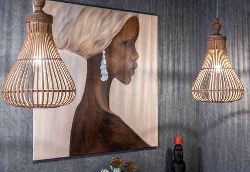 Free Artwork of ethnic female in headscarf and earring on wall between decorative lamps illuminating house room Stock Photo
