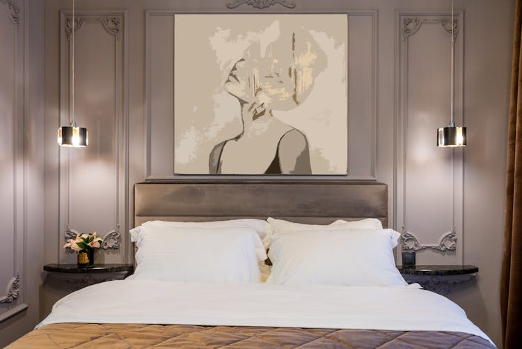 Modern Bedroom Interior With Soft Bed Under Painting Of Woman