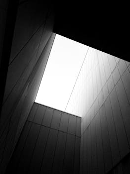 Black and white abstract architectural view from below of a modern building corner.