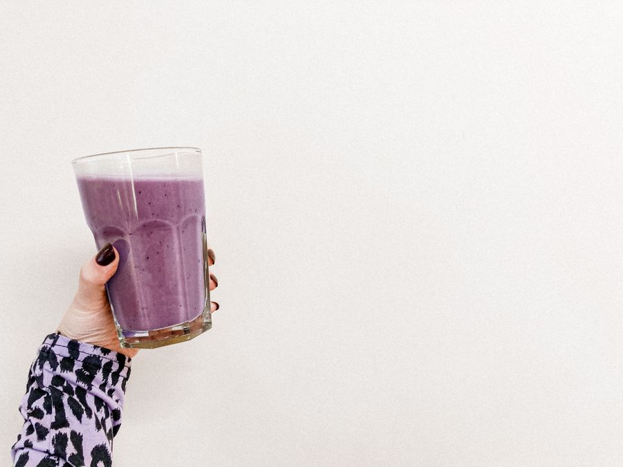 Hand holding a berry smoothie