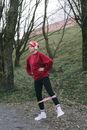 Woman in Red Sweater and Black Pants Standing on Green Grass Field