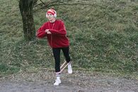 Woman in Red Hoodie Standing on Green Grass Field