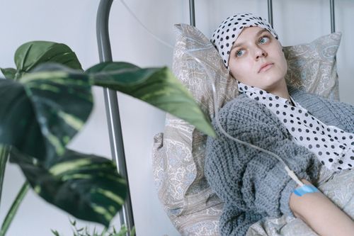 Free Young woman in hospital bed receiving cancer treatment, reflecting resilience. Stock Photo