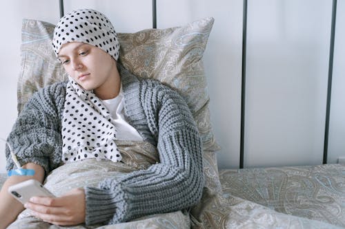 Woman in White and Black Polka Dot Hijab Sitting on Sofa