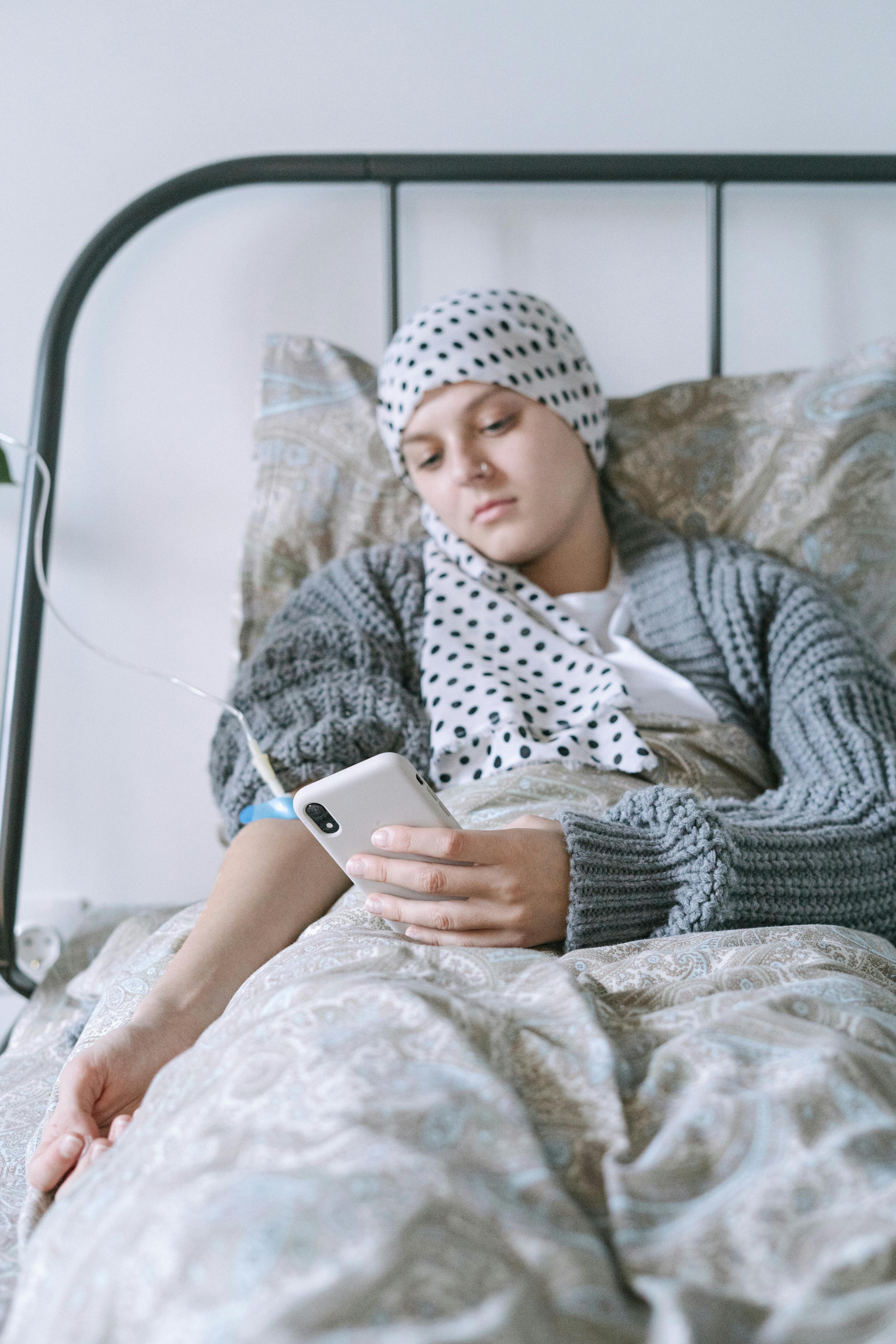 woman in gray sweater and white hijab holding silver iphone