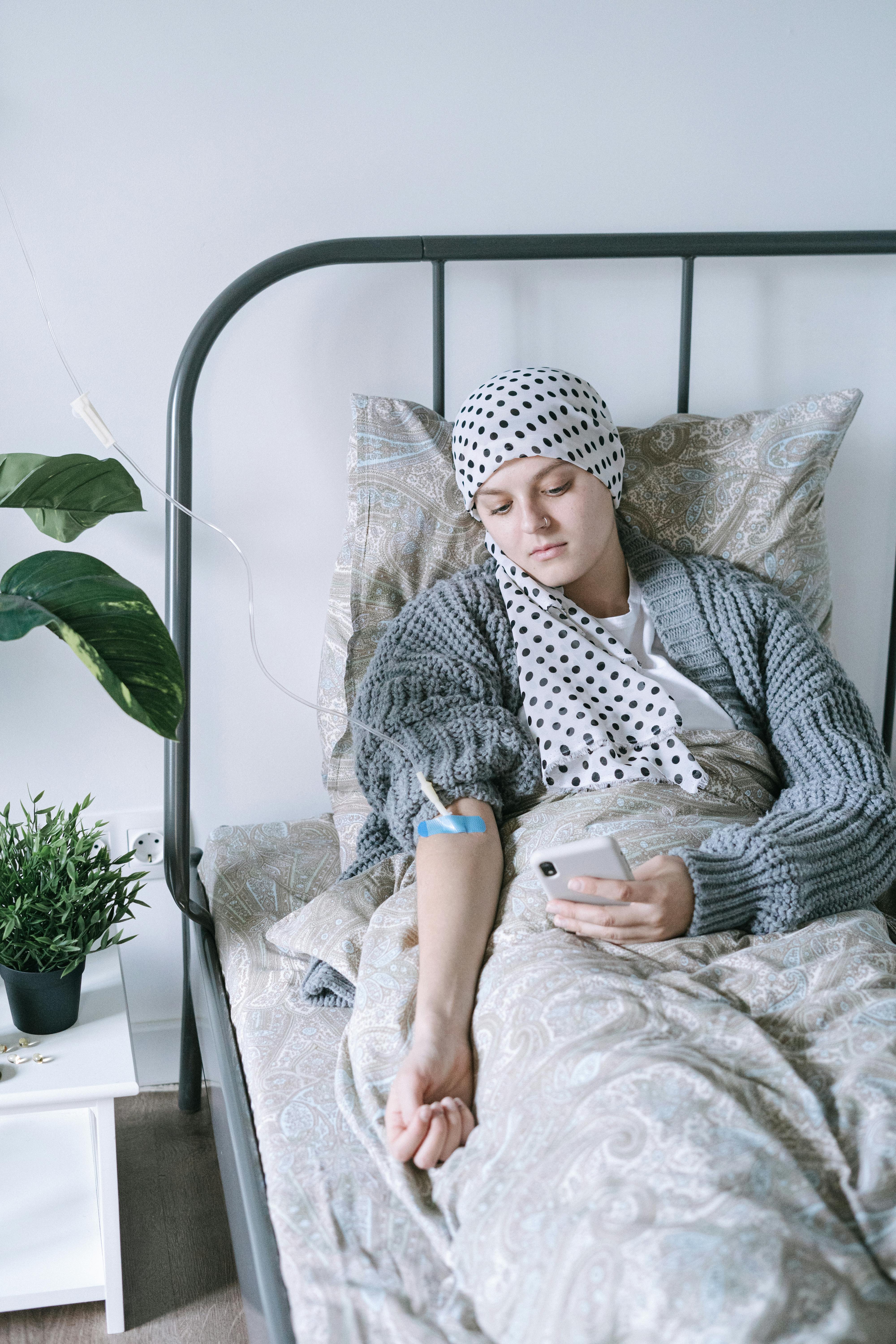 woman in gray and white polka dot robe sitting on bed