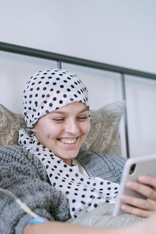Smiling Woman in White and Black Polka Dot Hijab Using Silver Ipad