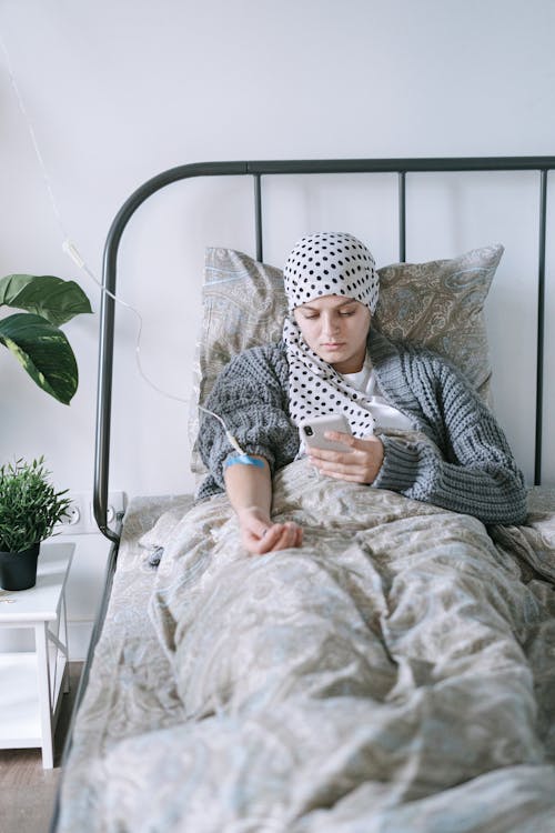 A Woman Using Her Phone while Undergoing Treatment