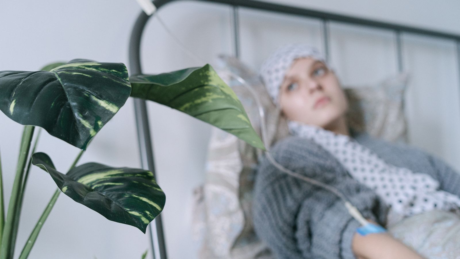 A cancer patient with an IV drip lies on a hospital bed, reflecting hope and recovery.