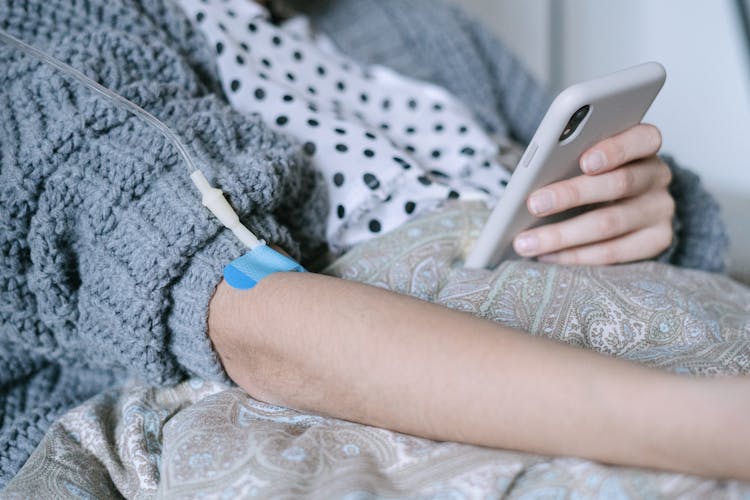 A Patient Using A Phone While Under Treatment