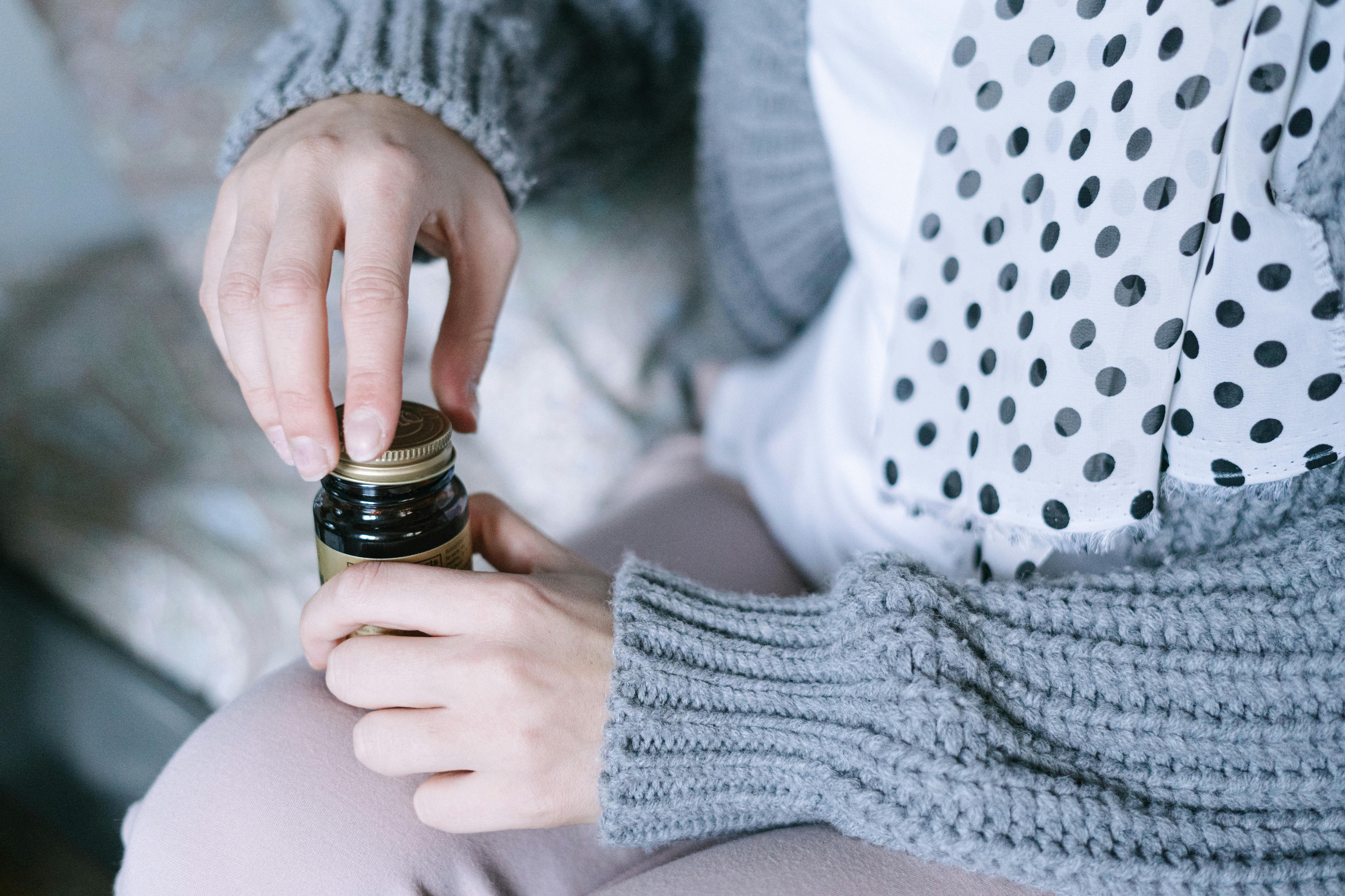 person holding black glass bottle