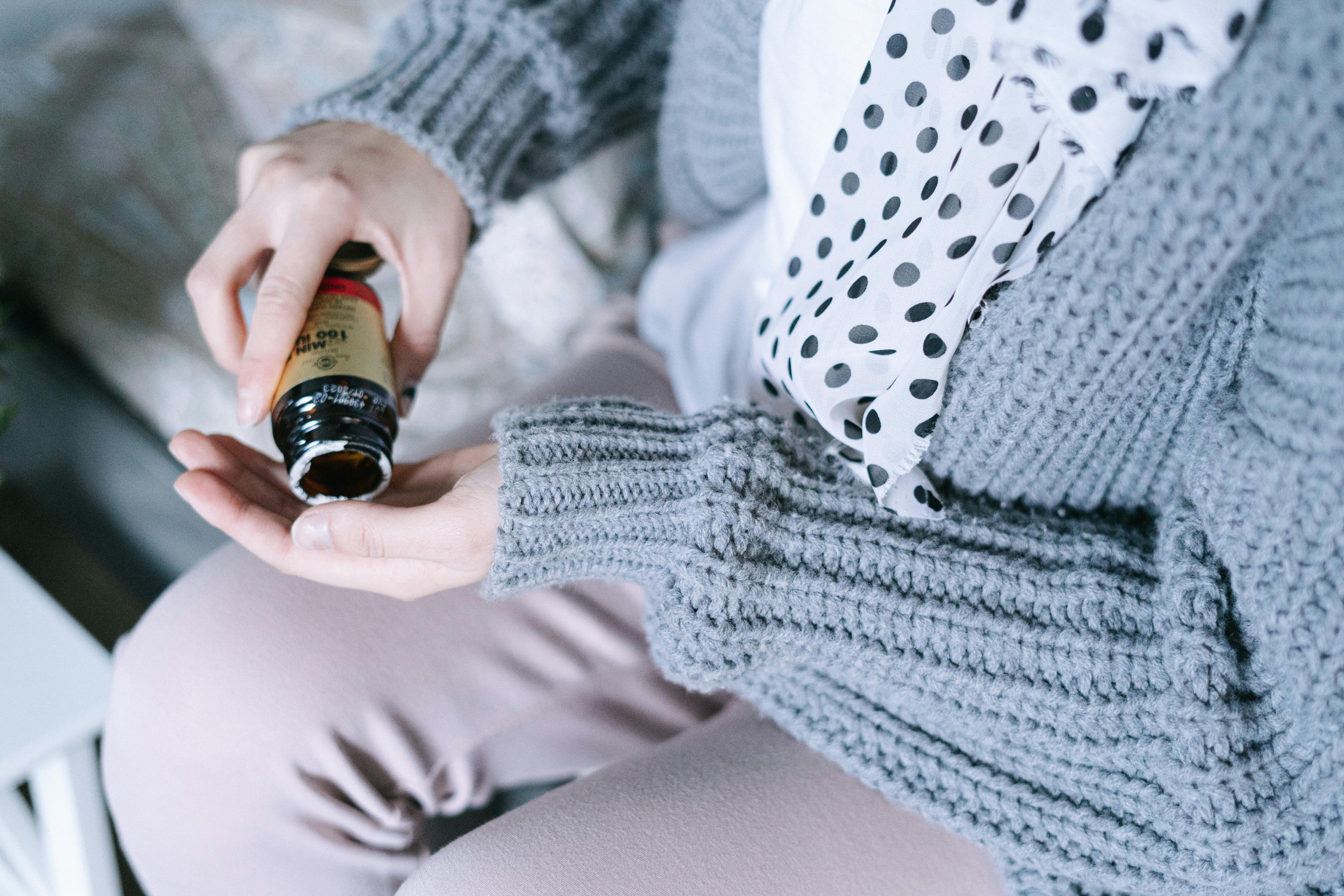 person holding black glass bottle