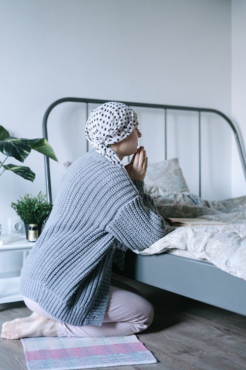 Woman in White and Black Hijab Sitting on Bed