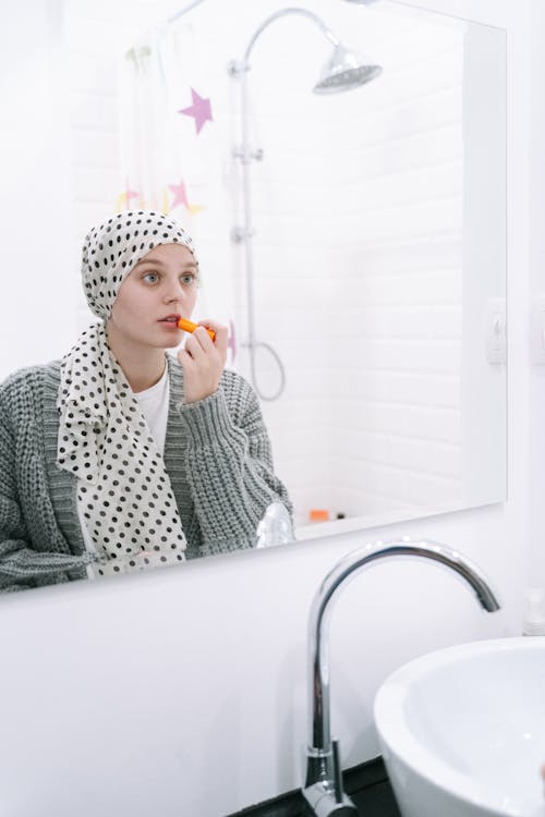 Woman in White and Black Hijab Sitting on White Bathtub