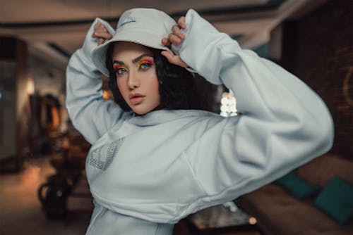 Stylish woman in hat in room