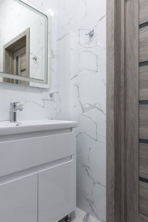 Free Washbasin with tap under mirror in modern bathroom Stock Photo