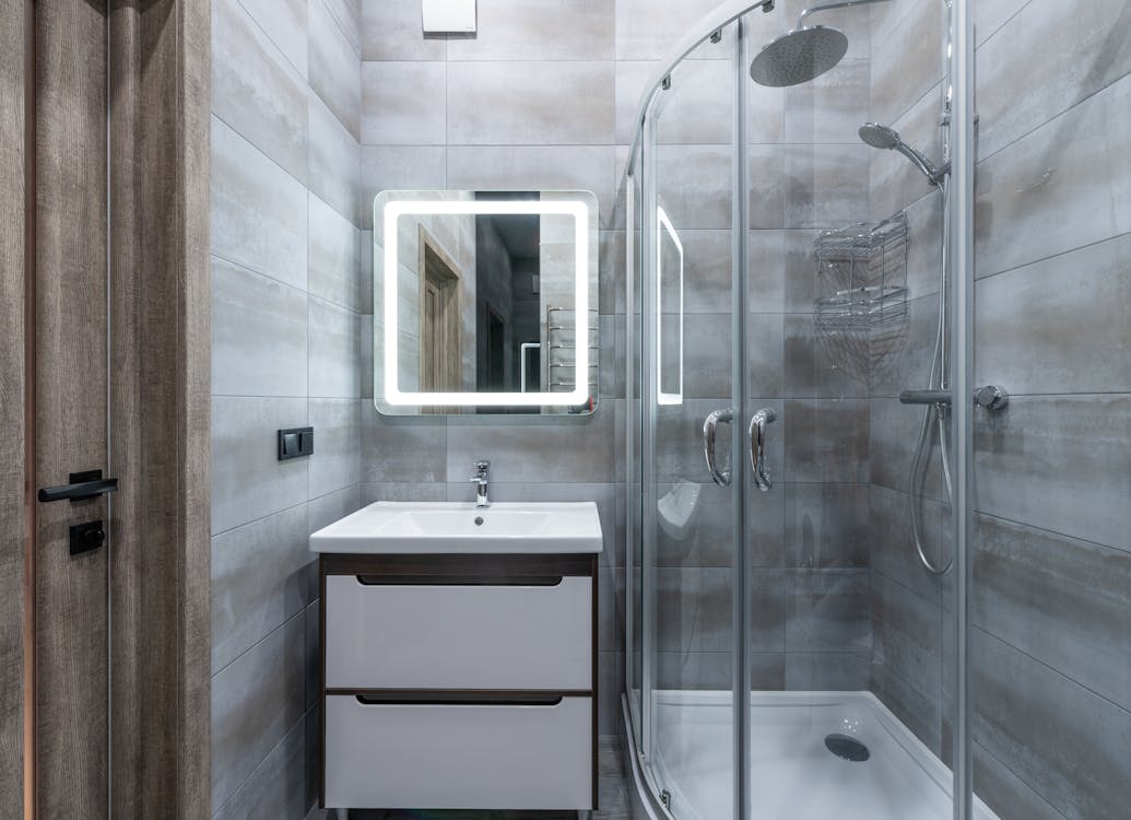 Free Contemporary washbasin under mirror against shower room with glass walls and tiles at home Stock Photo