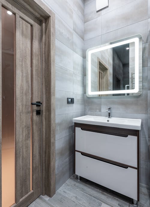 Contemporary bathroom interior with washbasin under mirror in house