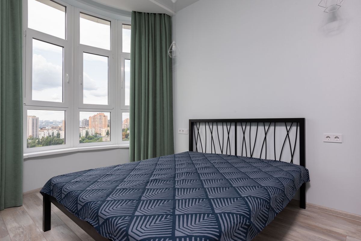 Contemporary student bedroom interior with wooden flooring and large window