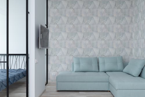 白と青の壁の横にある灰色のソファ