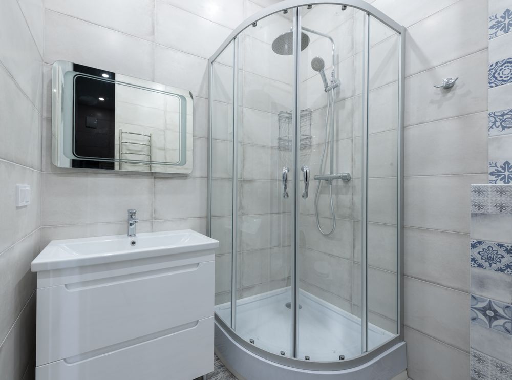 A renovated bathroom with a glass shower and vanity