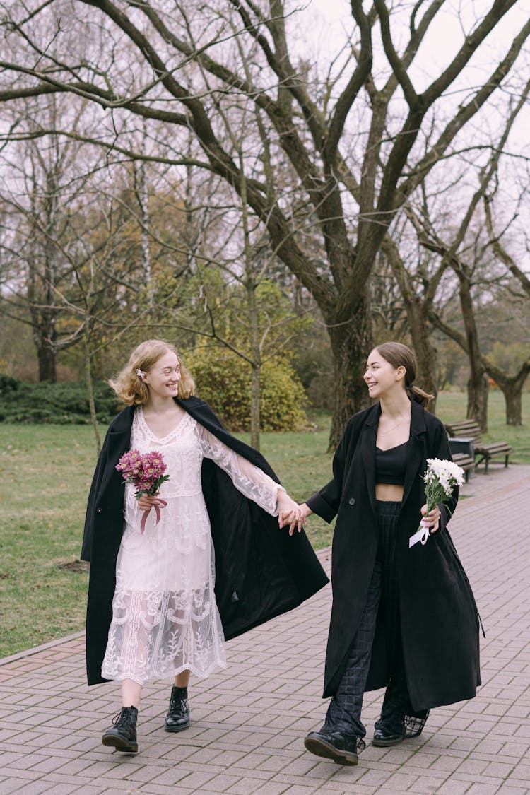 Women Walking Holding Hands In Park