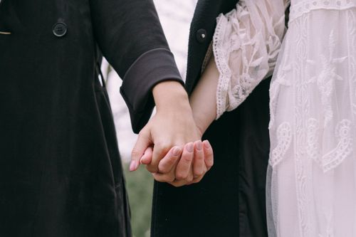 Free Close-up of two people holding hands, conveying love and togetherness outdoors. Stock Photo